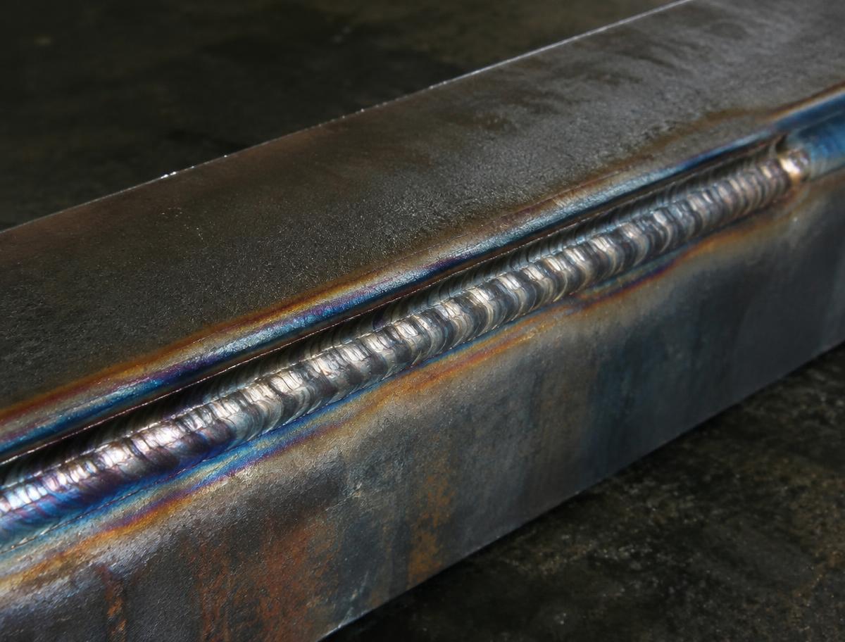 Close-up of a fresh weld bead on steel with heat tint